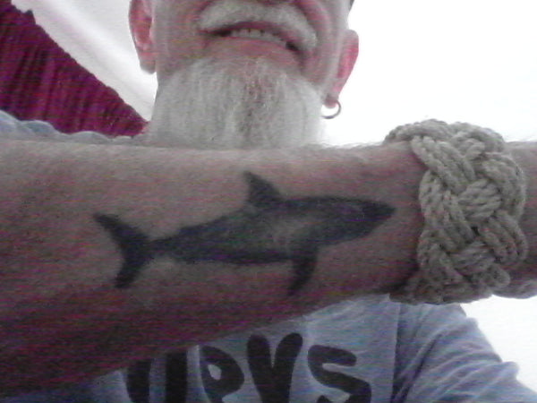 An old salt shows off his Turks Head bracelet and shark tattoo